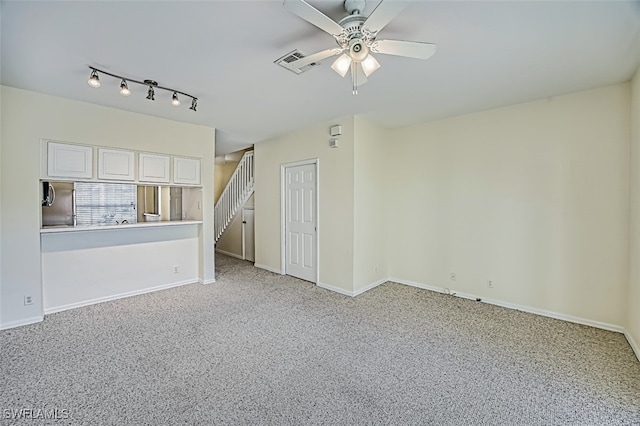 spare room featuring baseboards, visible vents, light colored carpet, ceiling fan, and stairway