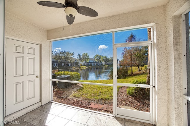 sunroom / solarium with a water view and a ceiling fan