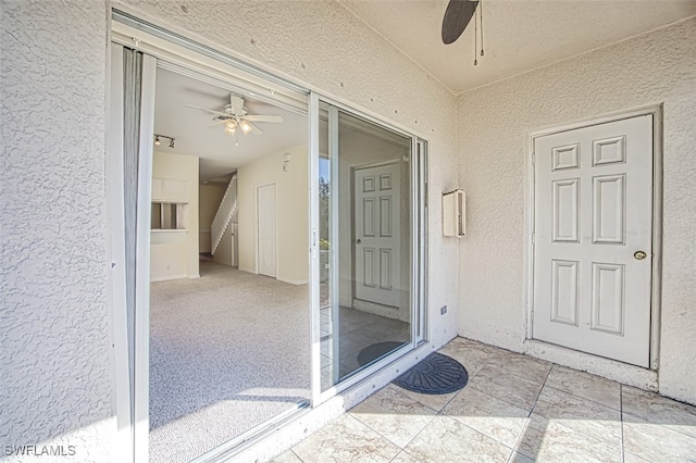 doorway to property featuring ceiling fan