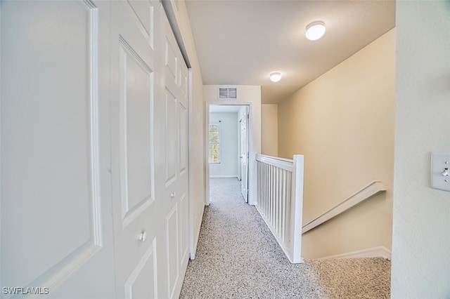 hall with an upstairs landing, visible vents, and baseboards