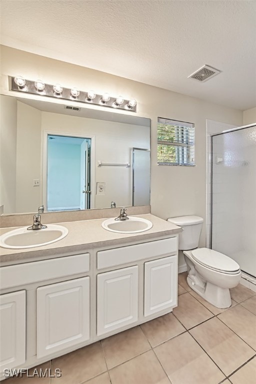 full bath with visible vents, a sink, a shower stall, and double vanity