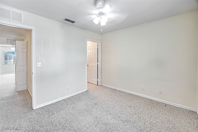 spare room featuring light carpet, visible vents, and baseboards