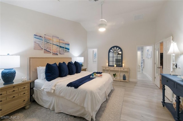 bedroom with high vaulted ceiling and light hardwood / wood-style floors