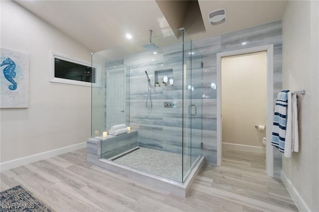 bathroom with lofted ceiling, wood-type flooring, a shower with door, and toilet