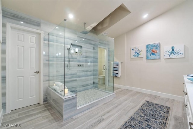 bathroom featuring vanity, hardwood / wood-style flooring, toilet, and walk in shower