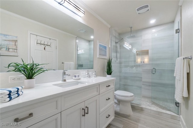 bathroom featuring vanity, crown molding, a shower with door, and toilet