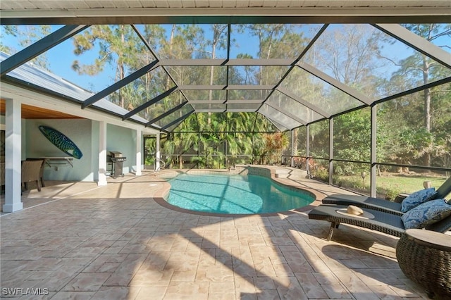 view of swimming pool featuring area for grilling, a patio, and glass enclosure