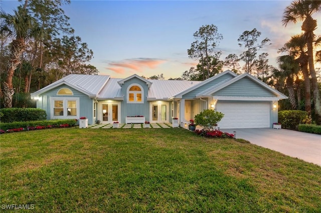 single story home featuring a garage, a yard, and french doors