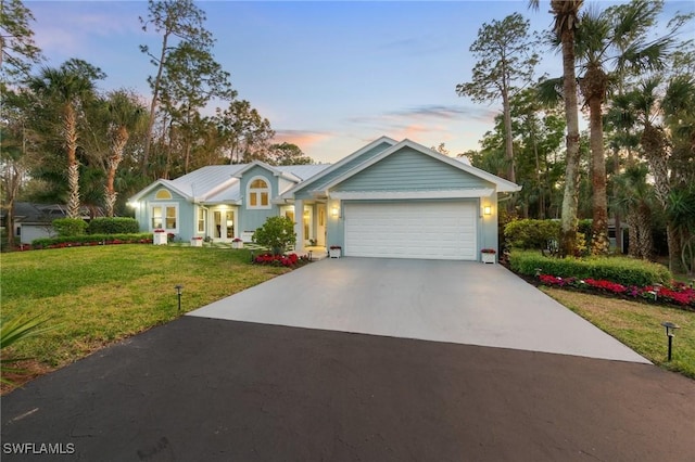 view of front of home with a yard and a garage