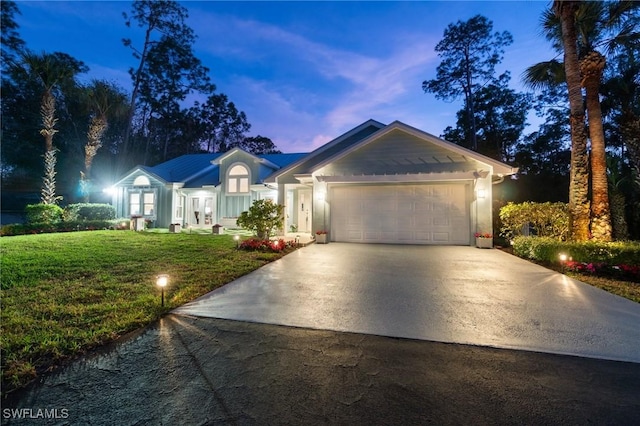 ranch-style house featuring a garage and a lawn