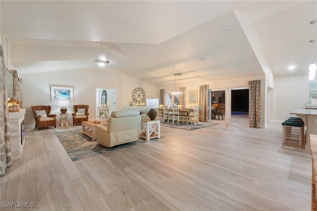 living room featuring lofted ceiling and light hardwood / wood-style floors