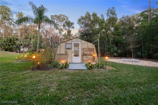 outdoor structure at dusk featuring a yard