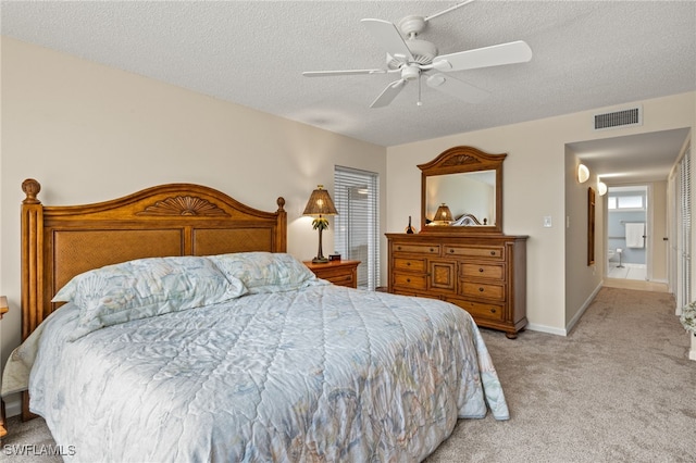 bedroom with light carpet, baseboards, visible vents, ceiling fan, and a textured ceiling