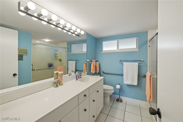 bathroom with baseboards, a shower stall, vanity, and tile patterned floors