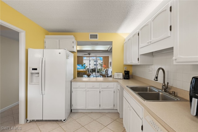 kitchen featuring white cabinets, white appliances, light countertops, and a sink