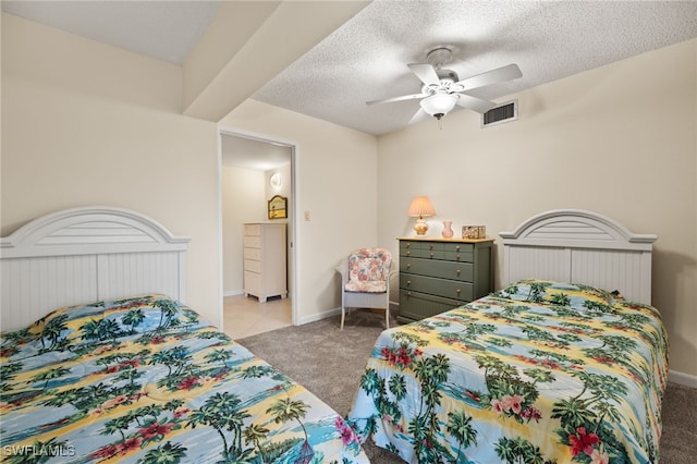 bedroom featuring light colored carpet, visible vents, a textured ceiling, and baseboards