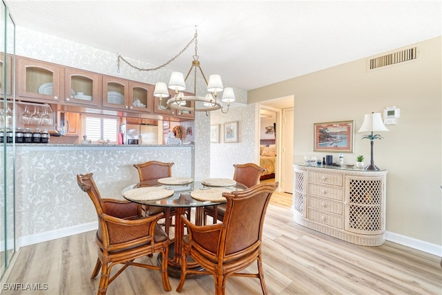 dining room featuring light wood-type flooring and a chandelier