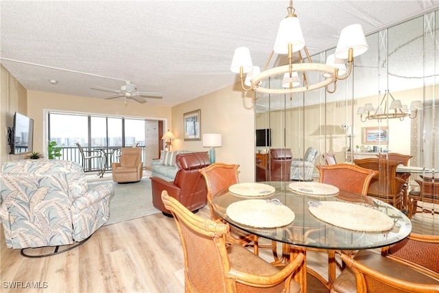 dining space featuring ceiling fan with notable chandelier, light hardwood / wood-style floors, and a textured ceiling