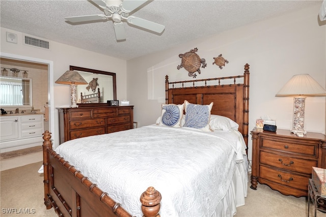 bedroom featuring a textured ceiling, light colored carpet, and ceiling fan