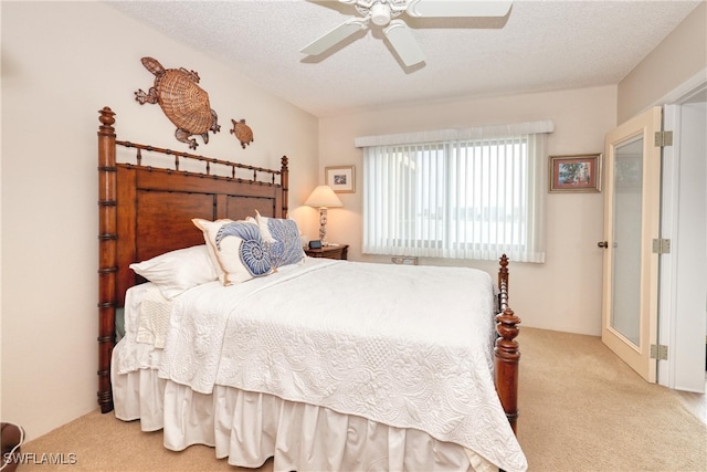 carpeted bedroom with ceiling fan and a textured ceiling