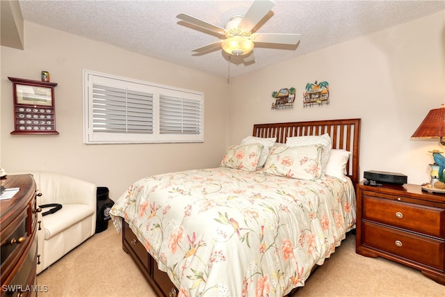 carpeted bedroom featuring ceiling fan and a textured ceiling