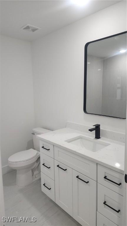 bathroom featuring toilet and vanity