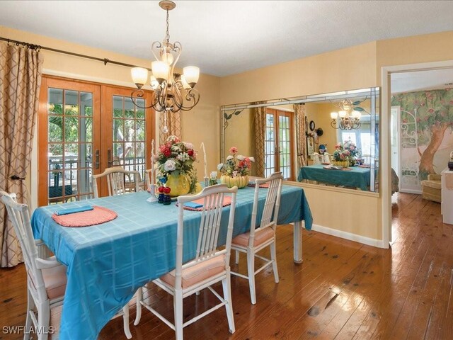 dining room with french doors, wood-type flooring, and a chandelier