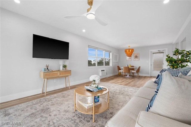 living room featuring an AC wall unit, ceiling fan, and light wood-type flooring