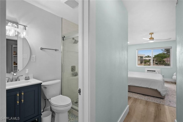 bathroom featuring toilet, a shower with door, ceiling fan, wood-type flooring, and vanity