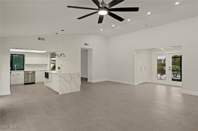 unfurnished living room with ceiling fan, sink, lofted ceiling, and french doors