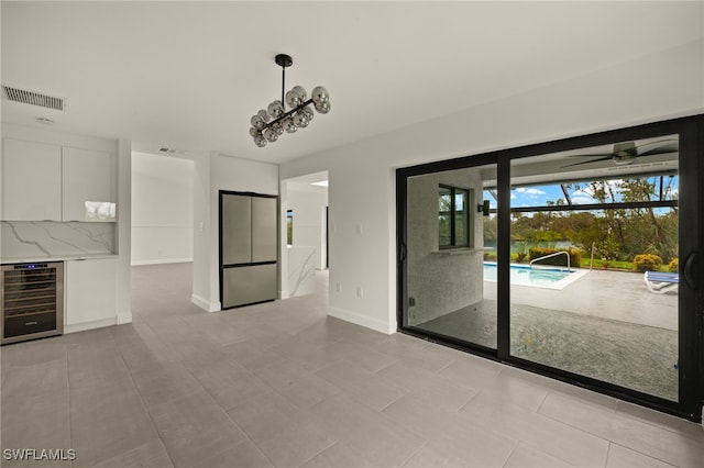 unfurnished living room with light tile patterned floors and beverage cooler