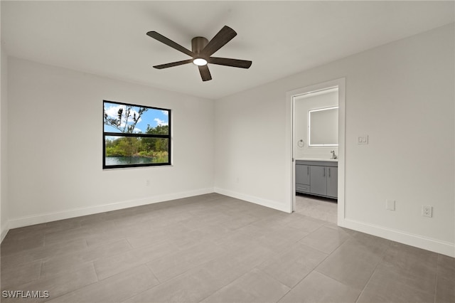 unfurnished room with ceiling fan, sink, and light tile patterned floors