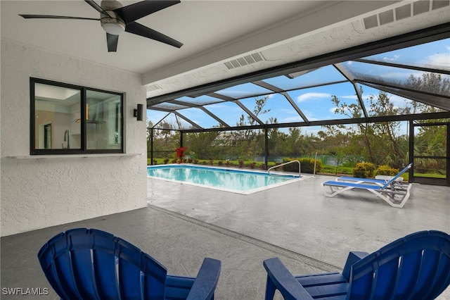 view of pool with glass enclosure, ceiling fan, and a patio area