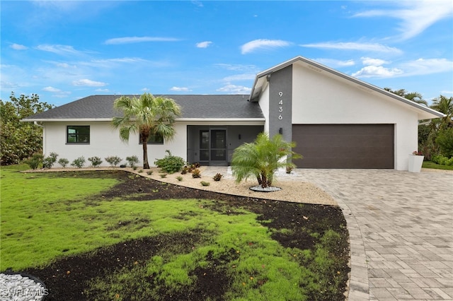 view of front of house with a garage and a front lawn