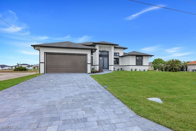 prairie-style home with a garage and a front lawn