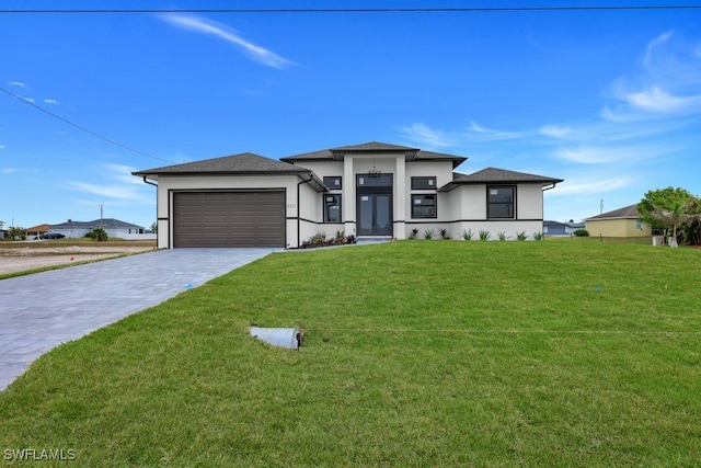 prairie-style house featuring a garage and a front lawn