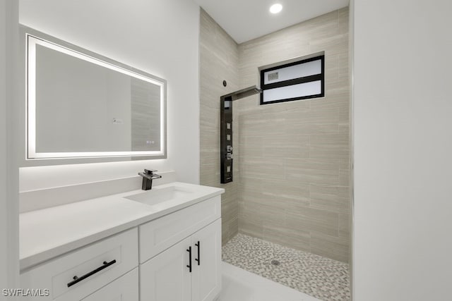 bathroom with vanity and a tile shower