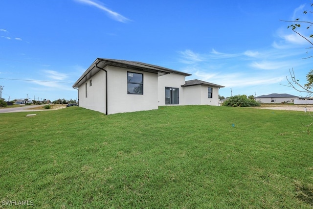 back of house with a lawn