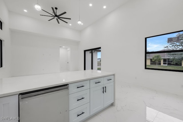 kitchen with decorative light fixtures, white cabinets, dishwasher, and a high ceiling