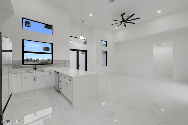 kitchen featuring dishwasher, white cabinetry, decorative backsplash, sink, and kitchen peninsula