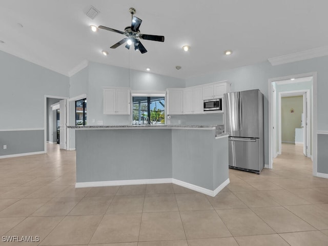 kitchen featuring vaulted ceiling, stainless steel appliances, white cabinets, and light stone counters