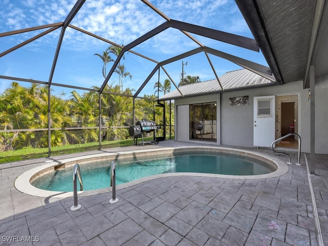 view of pool featuring glass enclosure and a patio area