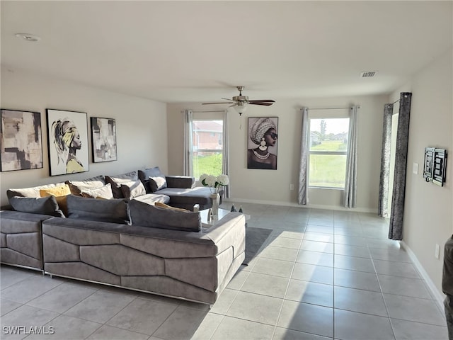 living room with light tile patterned floors, a healthy amount of sunlight, and ceiling fan