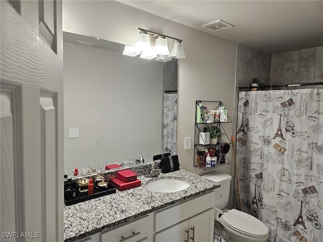 bathroom featuring vanity, walk in shower, and toilet