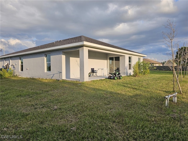 rear view of house with a yard and a patio