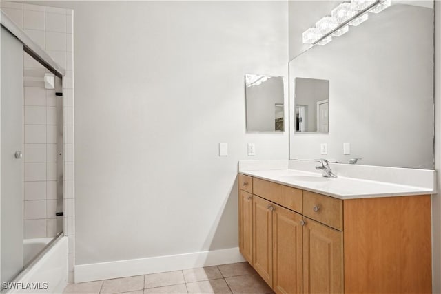 bathroom featuring tile patterned flooring, vanity, and combined bath / shower with glass door