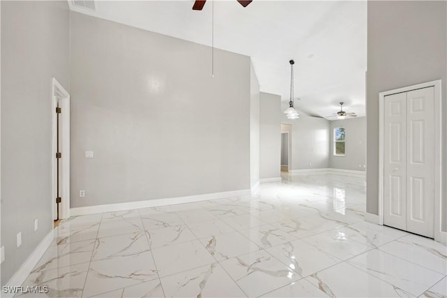 spare room with ceiling fan and high vaulted ceiling