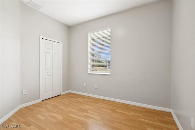 unfurnished bedroom featuring a closet and light hardwood / wood-style flooring