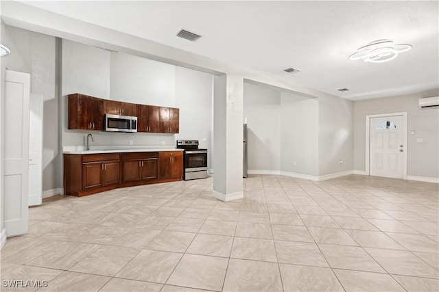 kitchen featuring sink, light tile patterned floors, stainless steel appliances, and a wall mounted AC