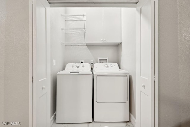 clothes washing area with independent washer and dryer and cabinets